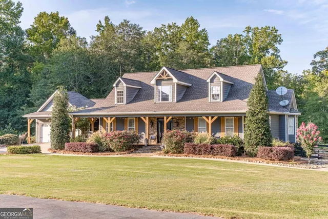 an aerial view of a house with swimming pool and lake view