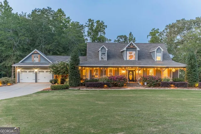 a view of a big house with a big yard and large trees