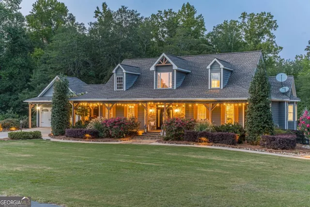 an aerial view of a house with outdoor space and trees all around