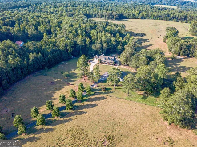a front view of a house with a garden and trees