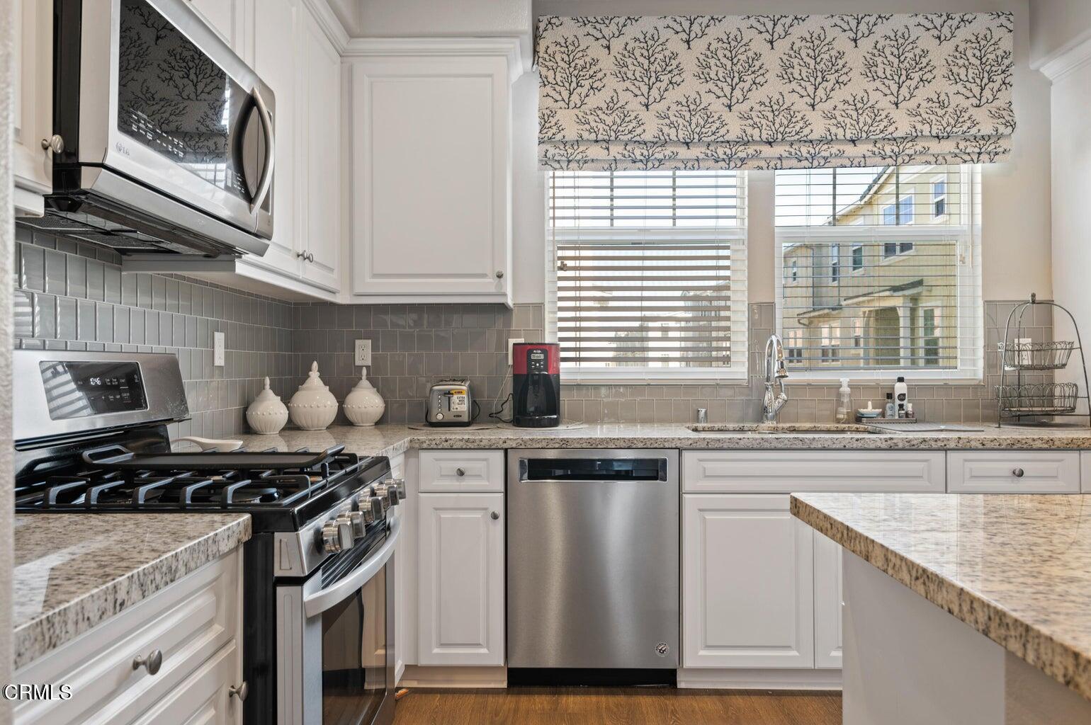 3661 West Hemlock Street Oxnard, CA 93035 - Photo 4 of 21 a kitchen with stainless steel appliances granite countertop a sink a stove and cabinets