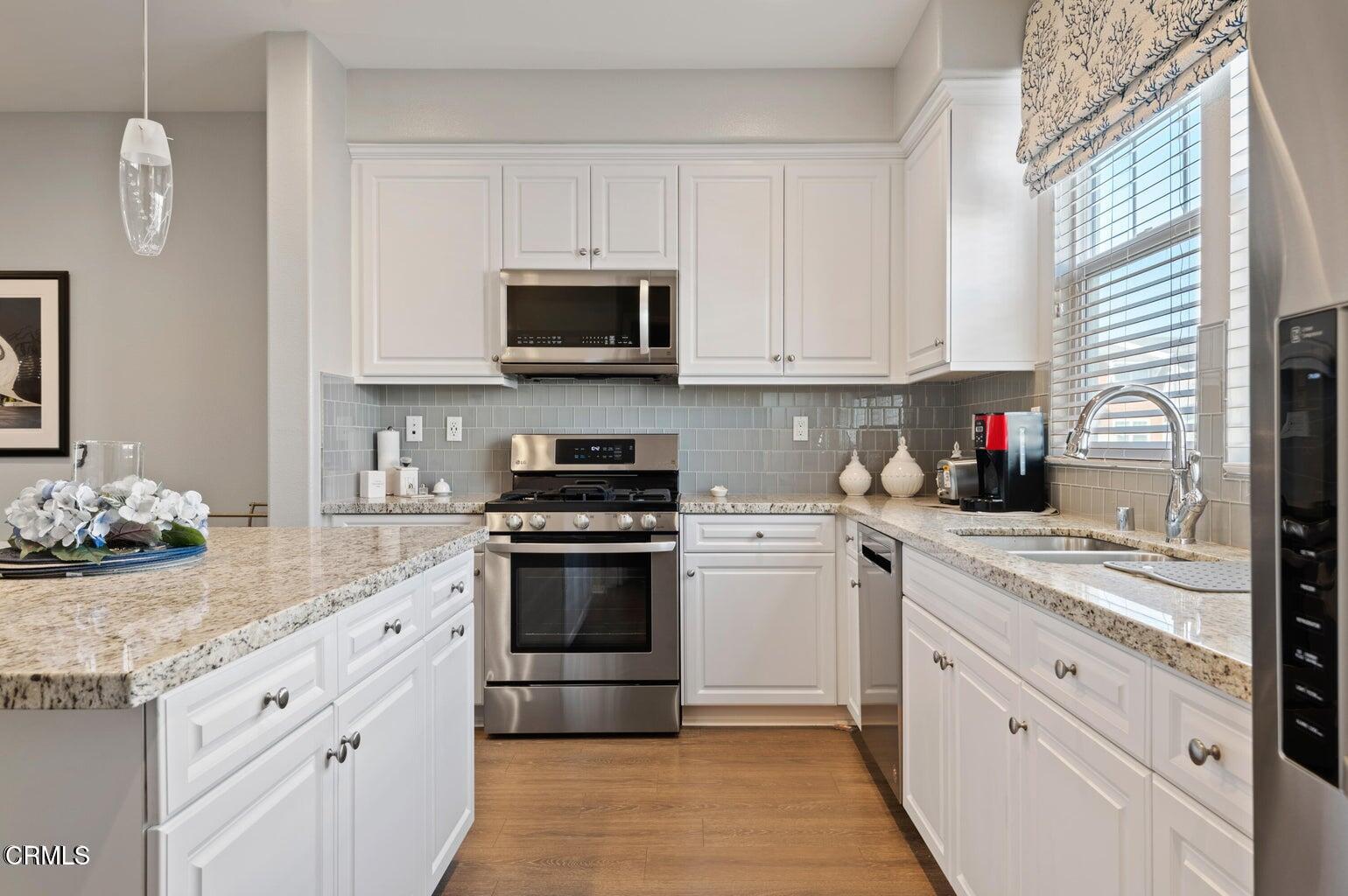 3661 West Hemlock Street Oxnard, CA 93035 - Photo 5 of 21 a kitchen with stainless steel appliances granite countertop a sink and a stove