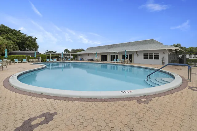 a view of a house with a swimming pool and a yard