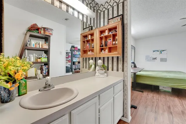 a bathroom with a sink a mirror and a wooden floor