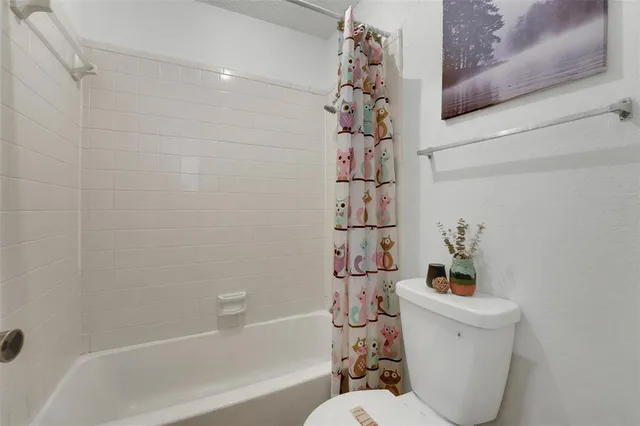 a white bath tub sitting next to a white toilet and sink