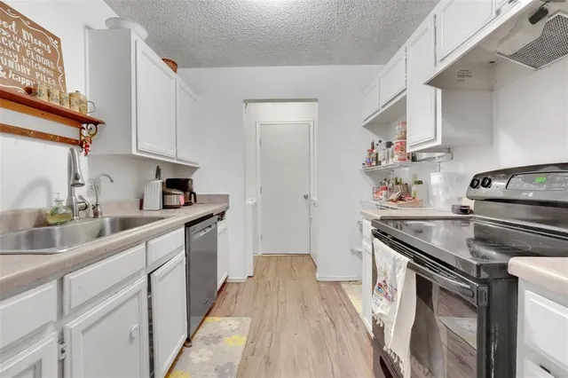 a kitchen with granite countertop a sink stove and refrigerator