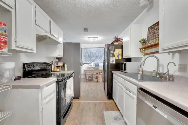 a kitchen with a sink dishwasher a stove and a refrigerator with wooden floor
