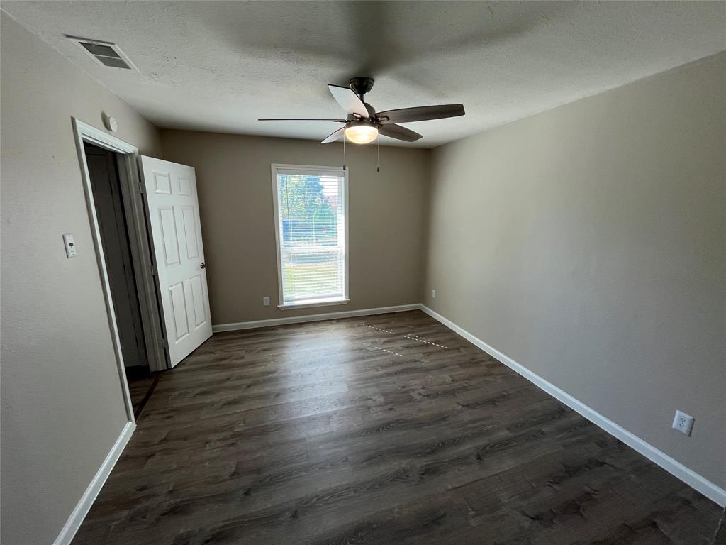 10037 Hymie Circle Dallas, TX 75217 - Photo 14 of 28 an empty room with wooden floor fan and windows