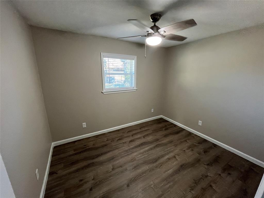 10037 Hymie Circle Dallas, TX 75217 - Photo 19 of 28 an empty room with wooden floor and windows
