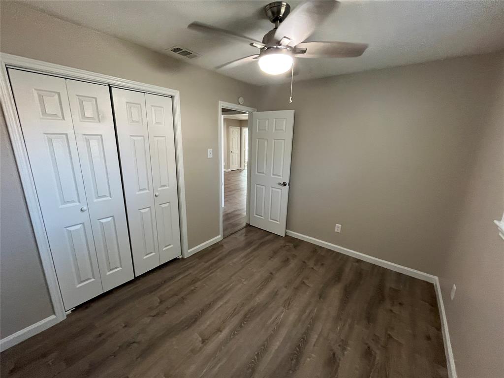 10037 Hymie Circle Dallas, TX 75217 - Photo 20 of 28 an empty room with wooden floor fan and windows