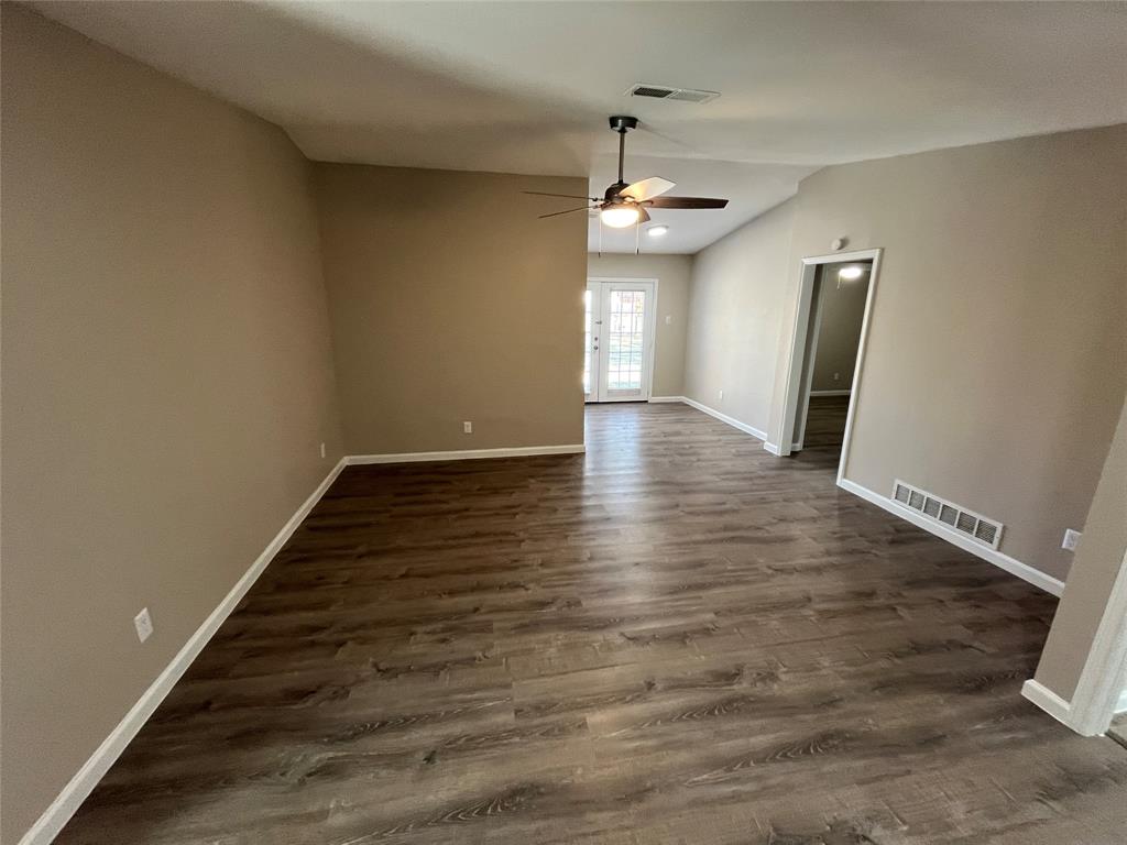 10037 Hymie Circle Dallas, TX 75217 - Photo 4 of 28 an empty room with wooden floor and windows