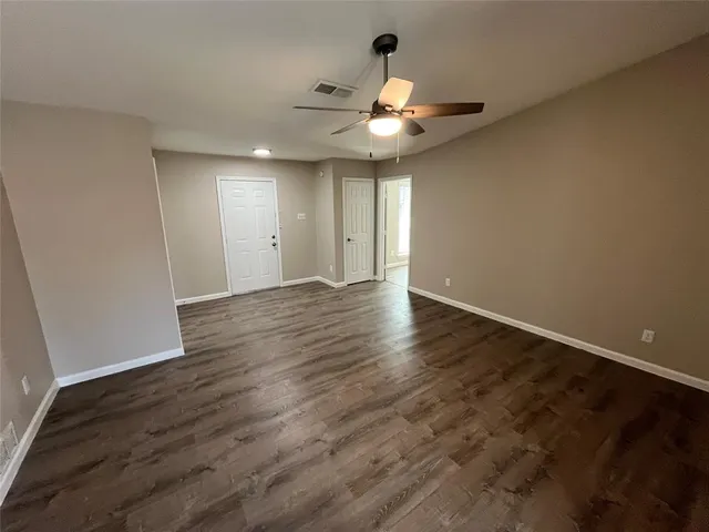 a view of an empty room with wooden floor