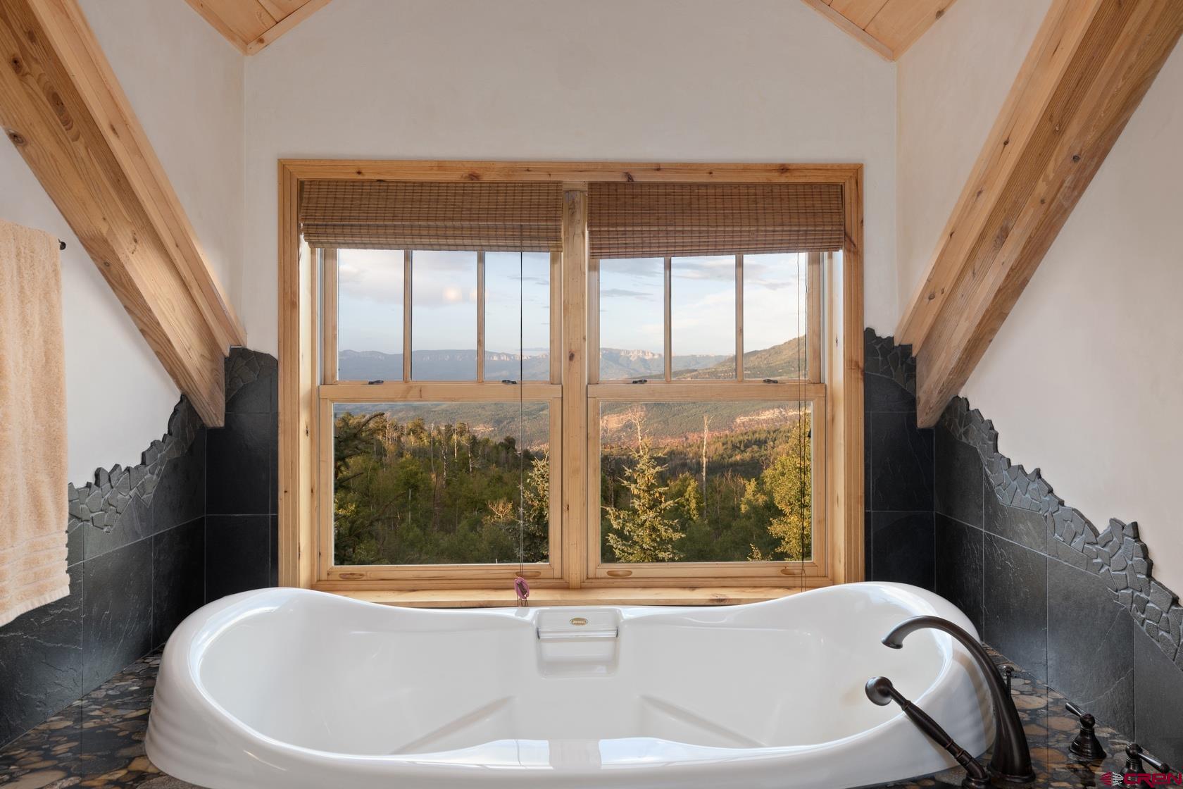9706 County Road 5 Ridgway, CO 81432 - Photo 19 of 33 a white bath tub sitting in a bathroom next to a window