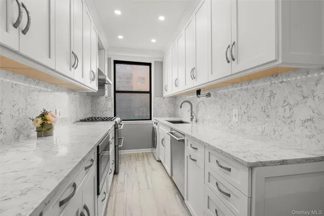 a kitchen with white cabinets and sink