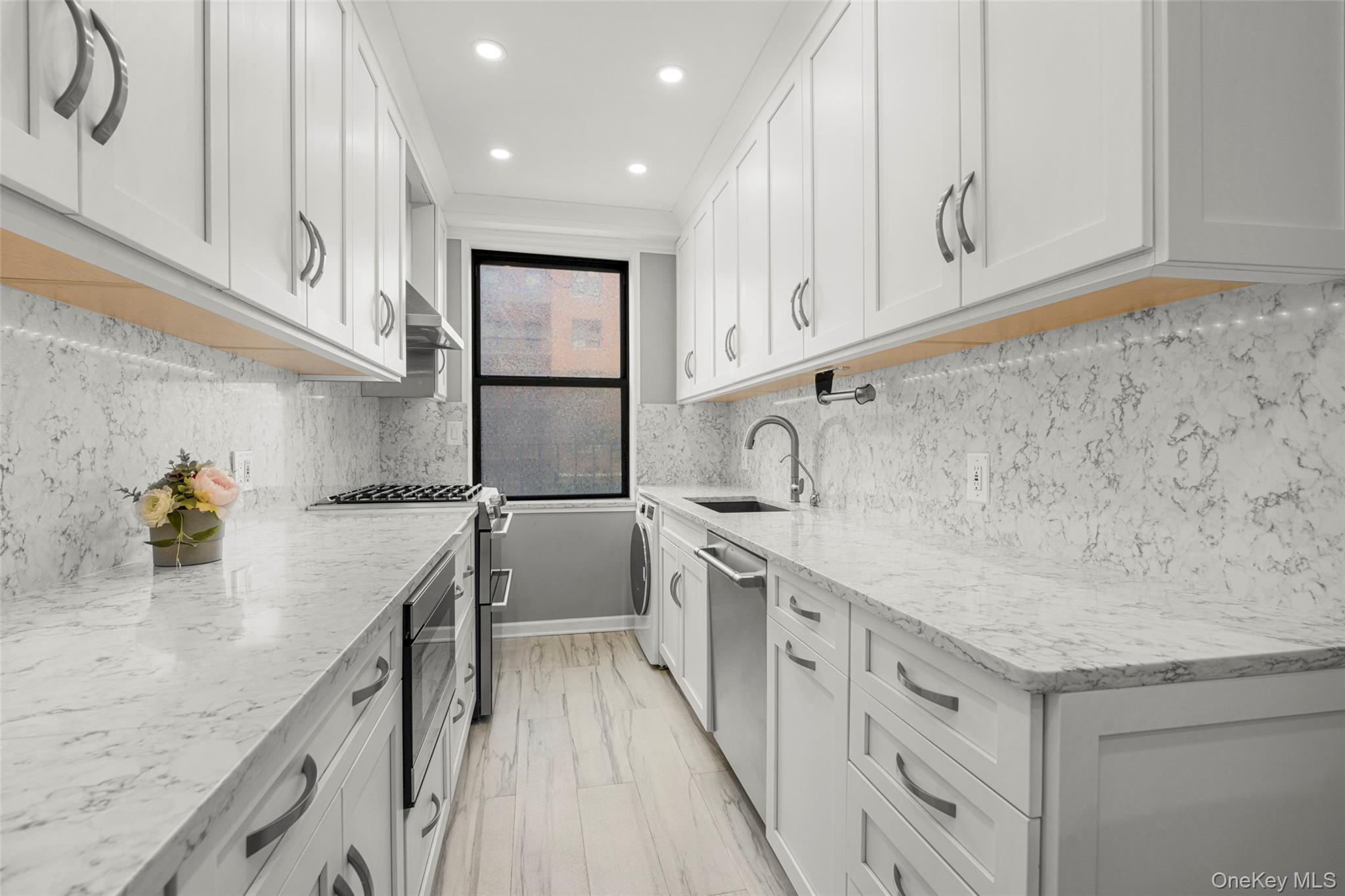 a kitchen with white cabinets and sink