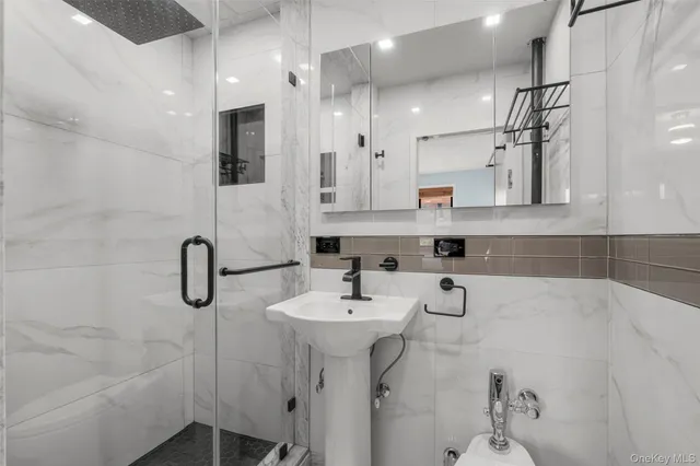 a bathroom with a sink a toilet and shower