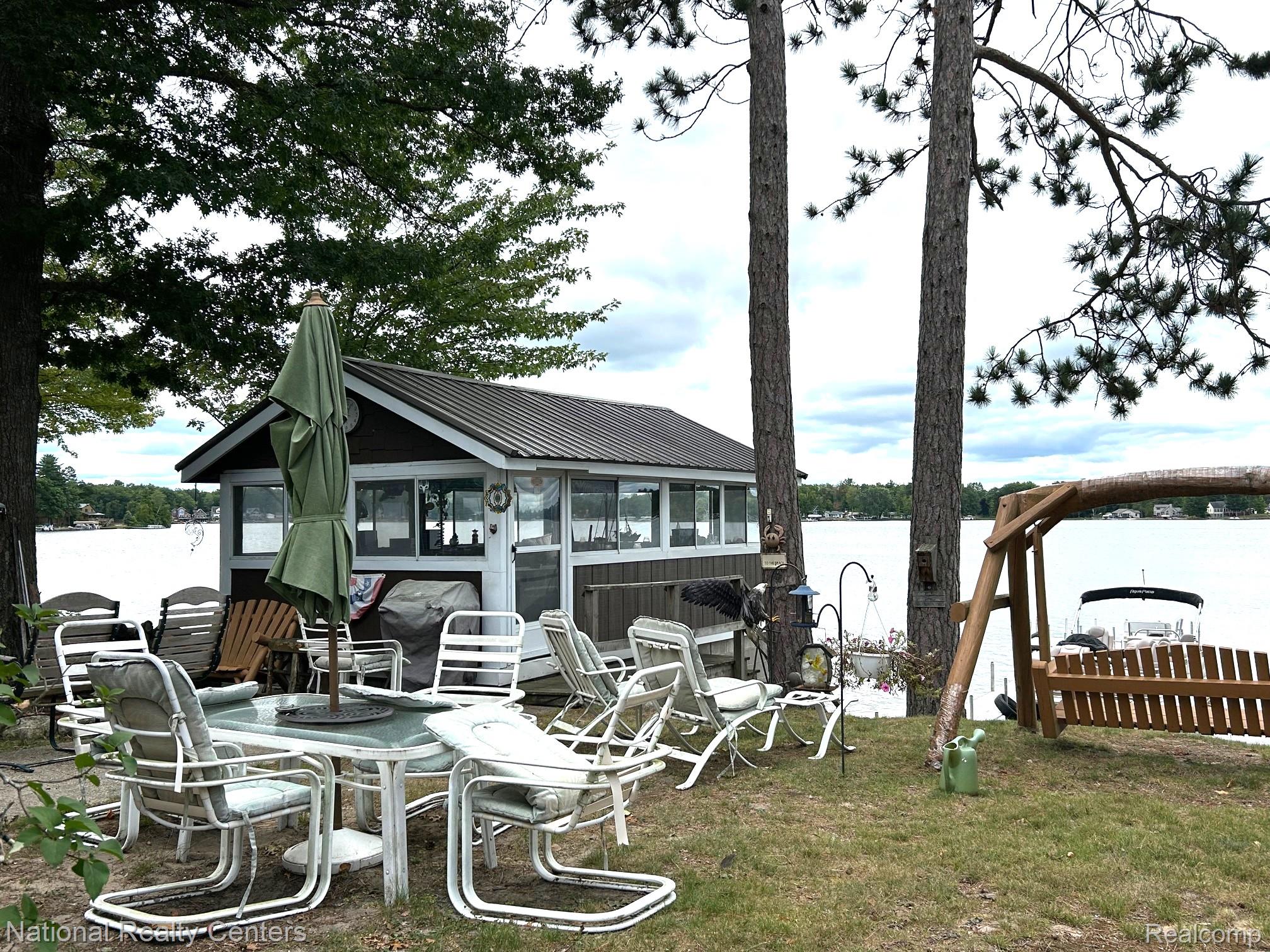 4951 Kokosing Road Hale, MI 48739 - Photo 13 of 37 Dock area featuring a sunroom, a yard, and a water view