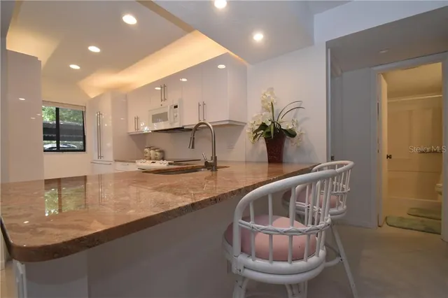 a kitchen with a table chairs sink and cabinets
