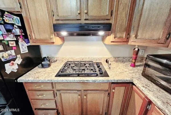 a kitchen with granite countertop a stove a sink and a microwave