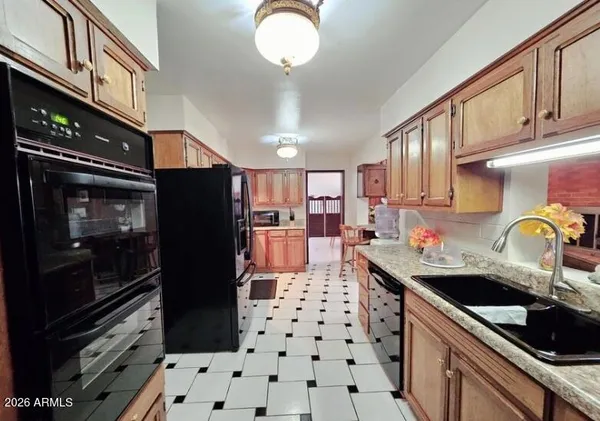 a kitchen with granite countertop a refrigerator and a sink