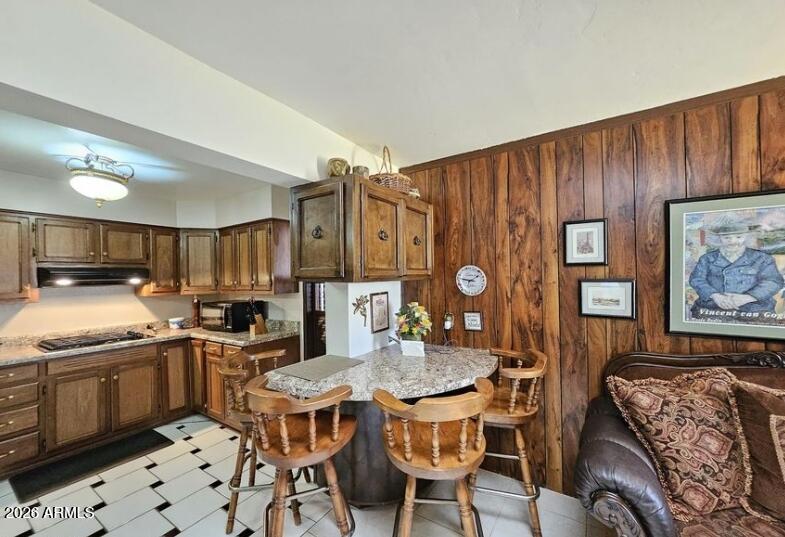 2201 East 7th Street Douglas, AZ 85607 - Photo 21 of 49 a kitchen with stainless steel appliances granite countertop a stove top oven a sink a dining table and chairs with wooden floor