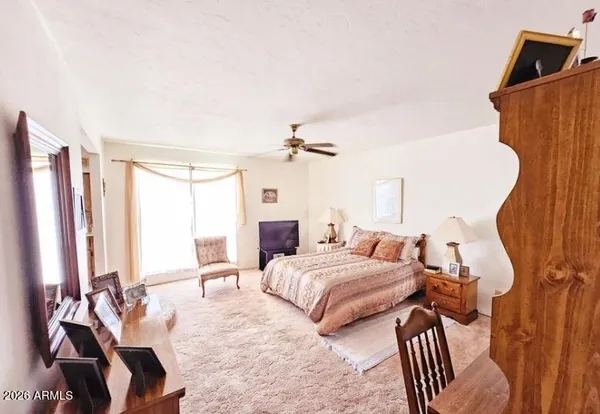 a bedroom with a large bed and a flat tv screen