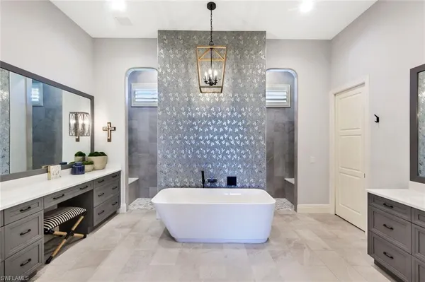 a bathroom with a tub a sink and mirror