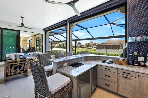 a kitchen with a large window and chairs