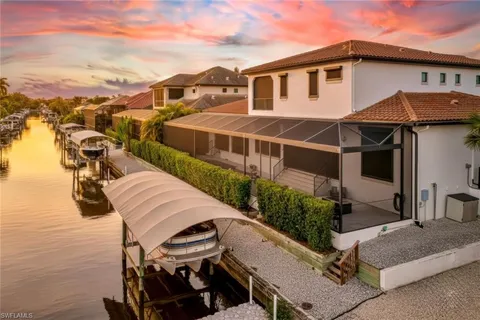 a view of a white house with a yard and furniture