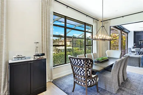 a dining room with furniture and large windows