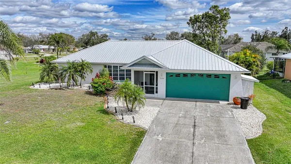 a view of a house with a yard and potted plants