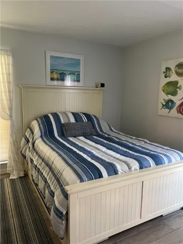 a bedroom with bed and painting on the wall