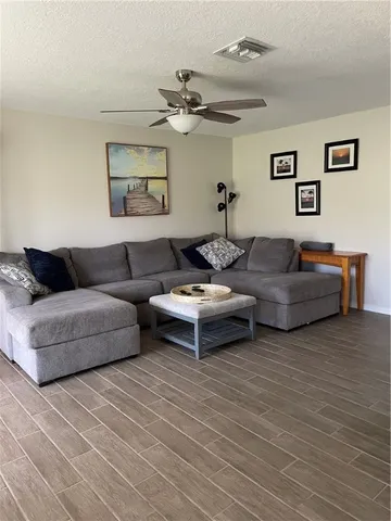 a living room with furniture and a wooden floor