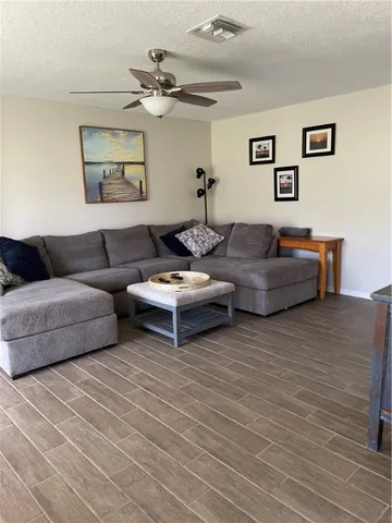 a living room with furniture and a wooden floor
