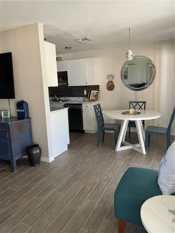 a living room with furniture a flat screen tv and kitchen view