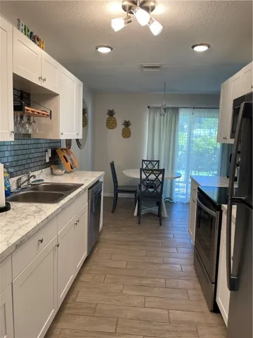 a kitchen with sink cabinets and stainless steel appliances