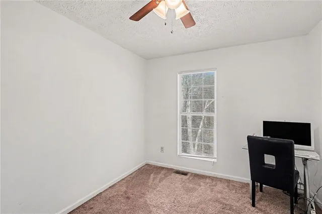 a bed sitting in a bedroom next to a window