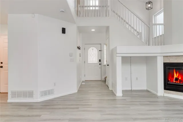 a view of a hallway with wooden floor and a chandelier