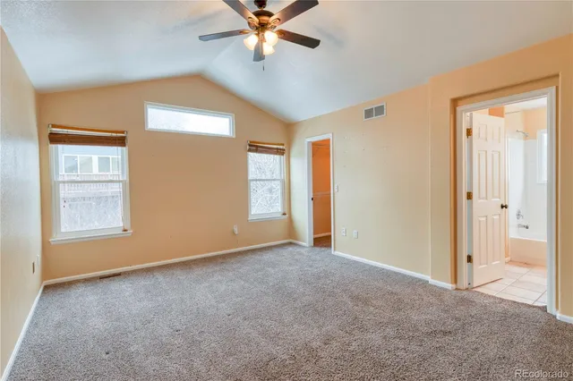 an empty room with closet and a chandelier fan