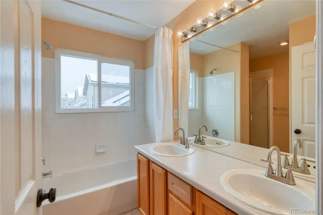 a bathroom with a sink double vanity granite tub and a mirror