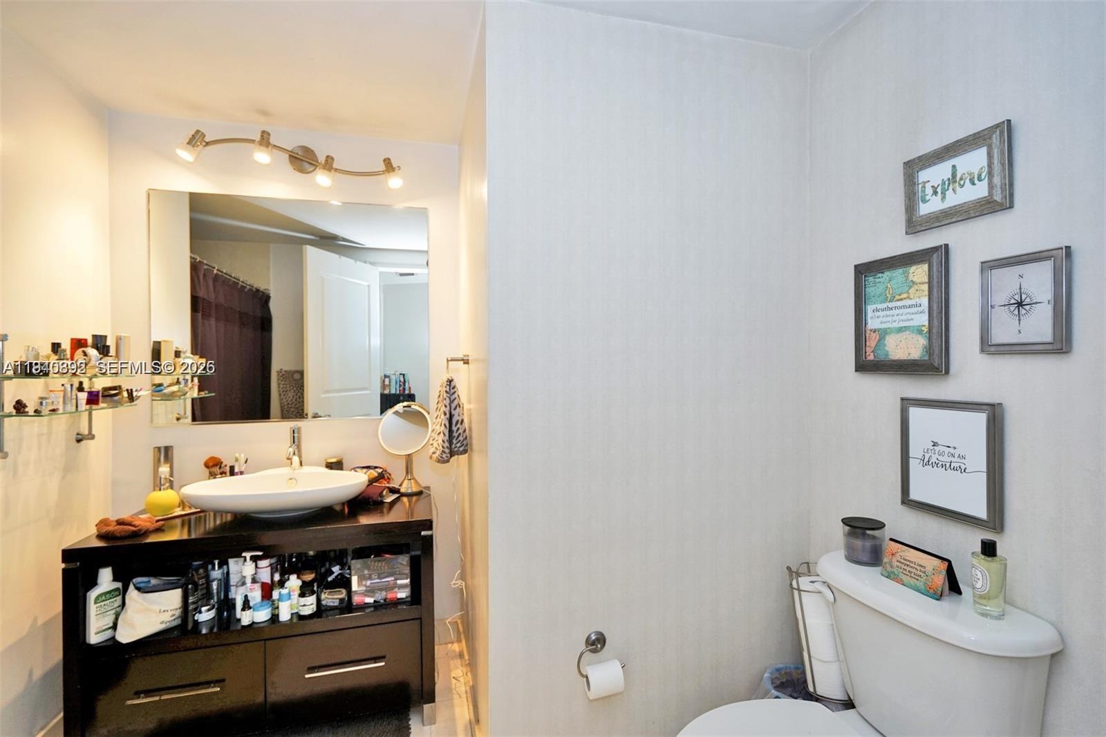 480 Northeast 30th Street, Unit 1403 Miami, FL 33137 - Photo 14 of 30 a bathroom with a toilet sink and mirror