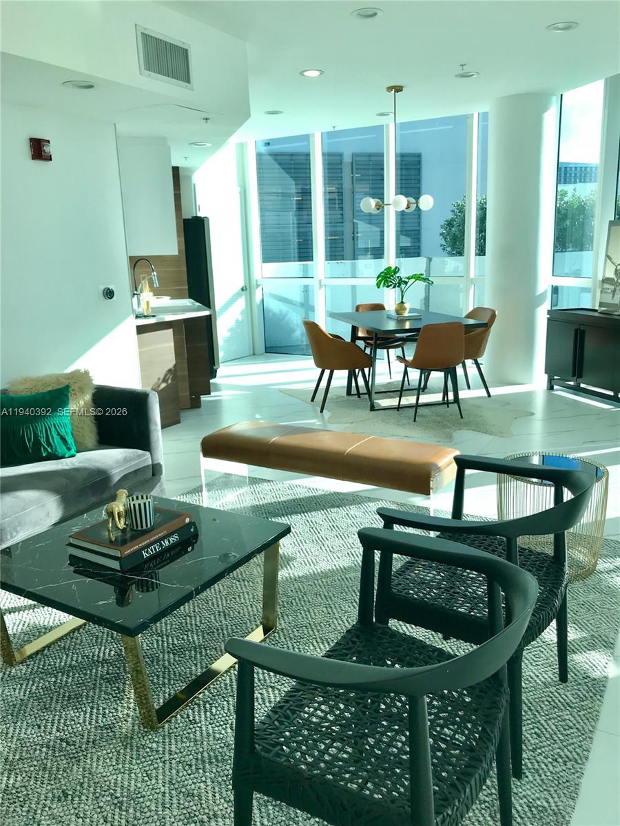 480 Northeast 30th Street, Unit 1403 Miami, FL 33137 - Photo 23 of 30 a dining room with furniture and a floor to ceiling window