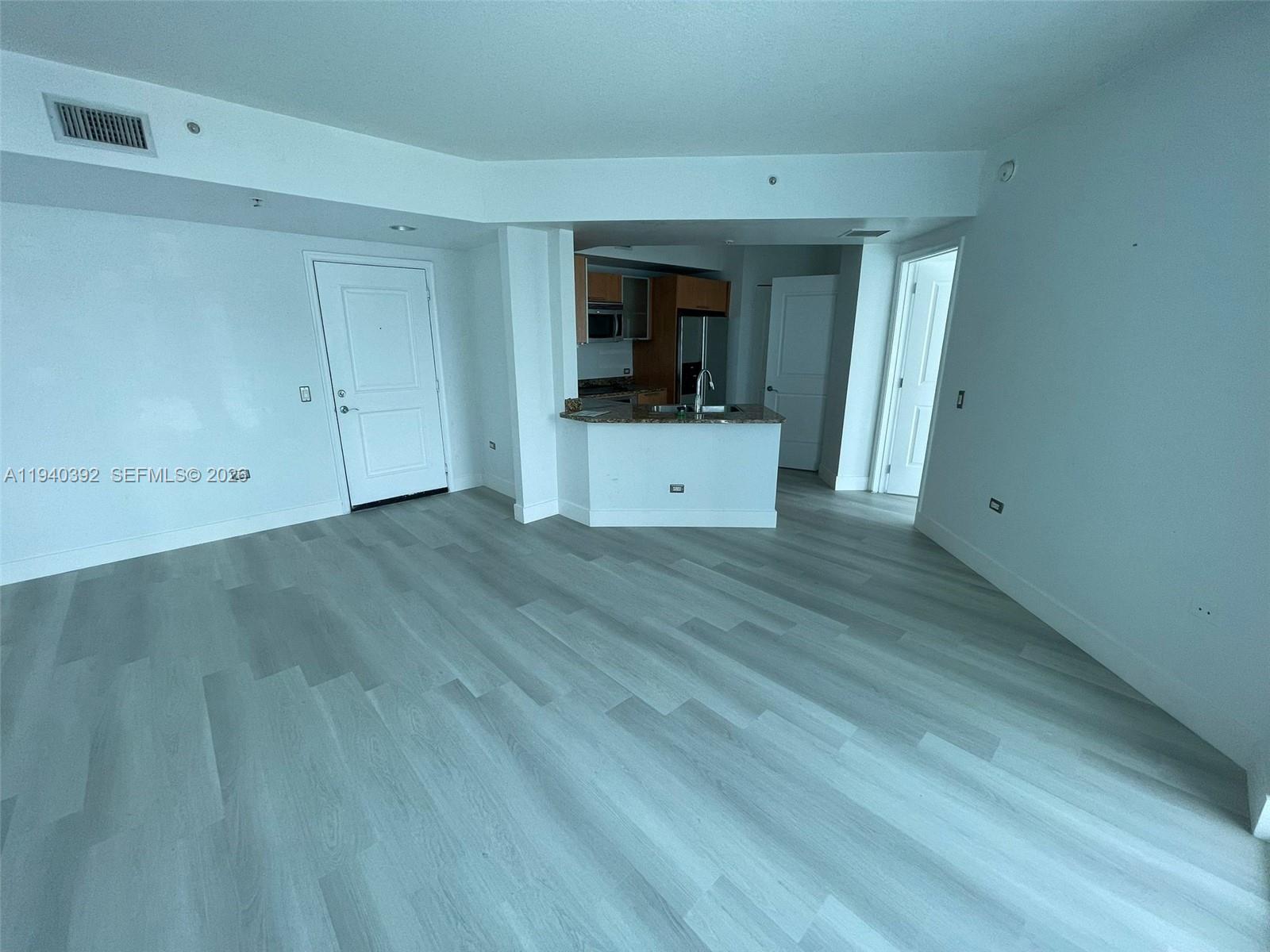 480 Northeast 30th Street, Unit 1403 Miami, FL 33137 - Photo 6 of 30 a view of a room with wooden floor and white wall