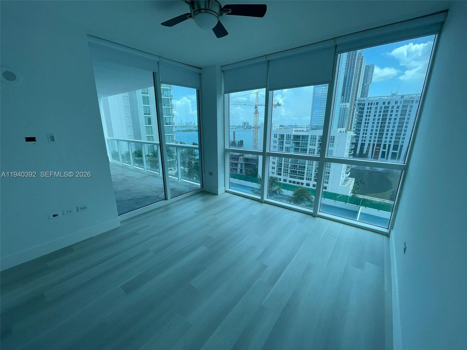 480 Northeast 30th Street, Unit 1403 Miami, FL 33137 - Photo 9 of 30 an empty room with wooden floor and windows