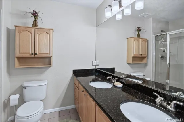 a bathroom with a granite countertop sink vanity mirror and toilet