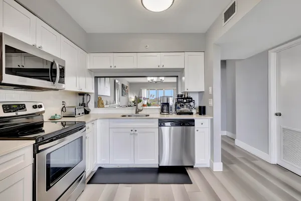a living room with furniture a flat screen tv and kitchen view