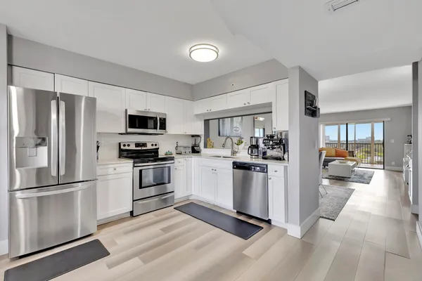 a kitchen with stainless steel appliances a stove microwave and refrigerator