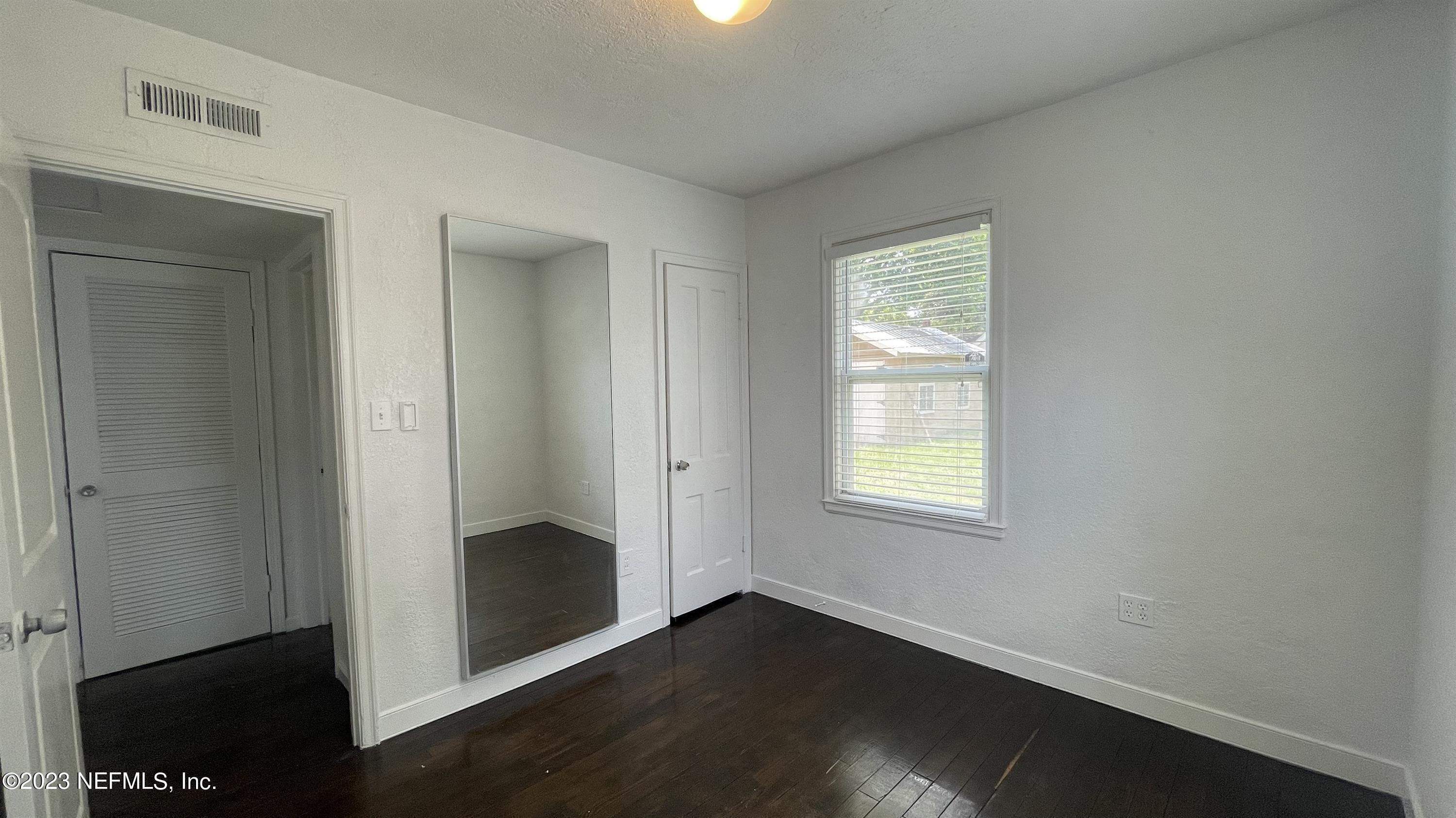 5228 Sunderland Road Jacksonville, FL 32210 - Photo 13 of 18 an empty room with wooden floor closet and windows