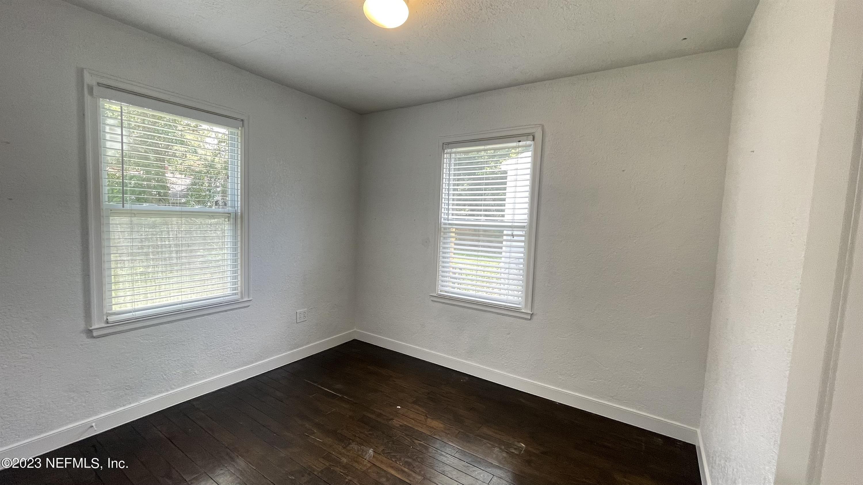 5228 Sunderland Road Jacksonville, FL 32210 - Photo 14 of 18 an empty room with wooden floor and windows