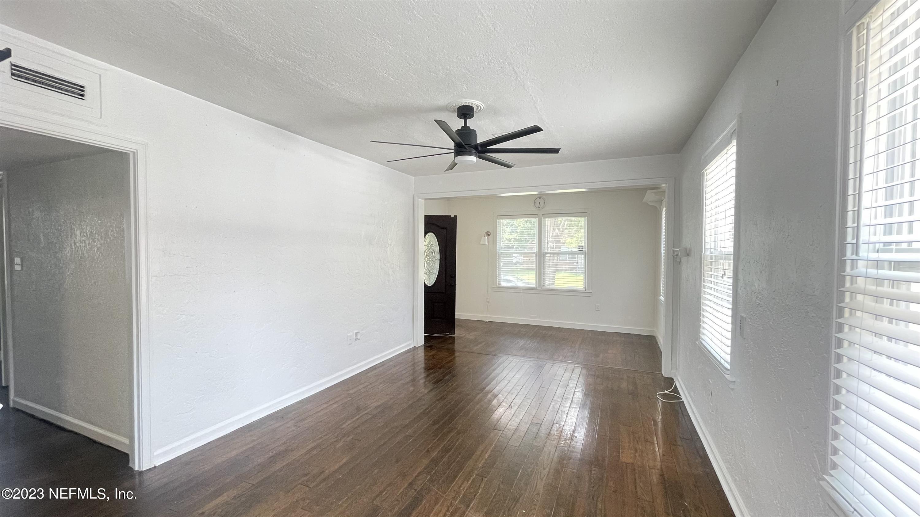 5228 Sunderland Road Jacksonville, FL 32210 - Photo 7 of 18 a view of empty room with wooden floor and fan